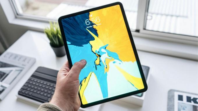 Turot rokās iPad Pro ar spilgtām tapetēm